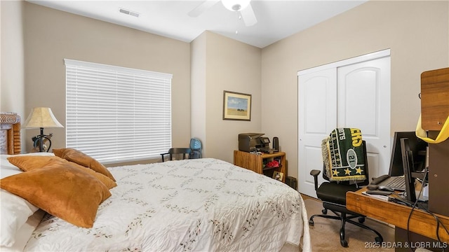 bedroom featuring carpet floors, ceiling fan, visible vents, and a closet