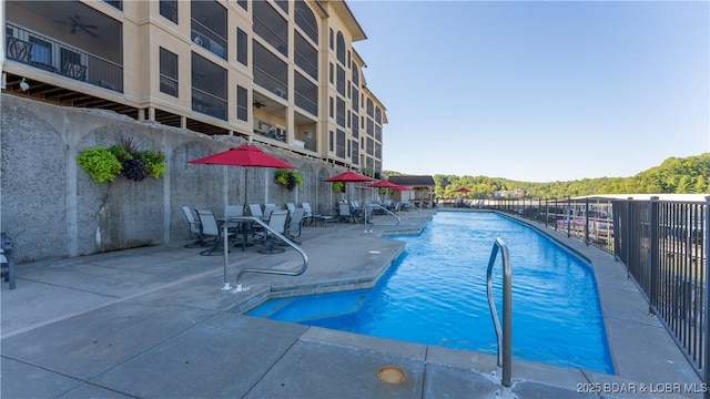 pool with fence and a patio