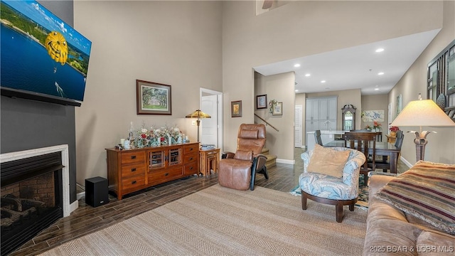 living area featuring a fireplace, recessed lighting, baseboards, and wood tiled floor