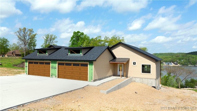 view of front of property featuring roof with shingles and concrete driveway