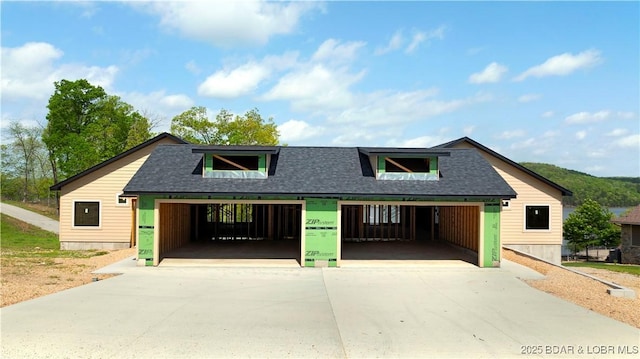 view of front of home featuring roof with shingles and a garage