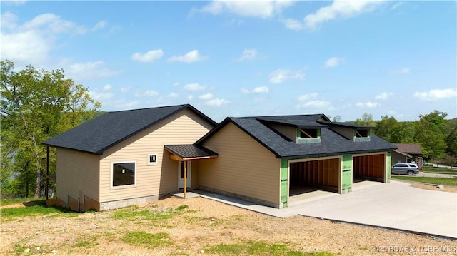 view of front of property with a garage, a shingled roof, and driveway