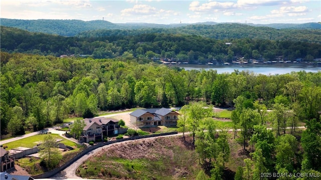 drone / aerial view with a forest view and a water view