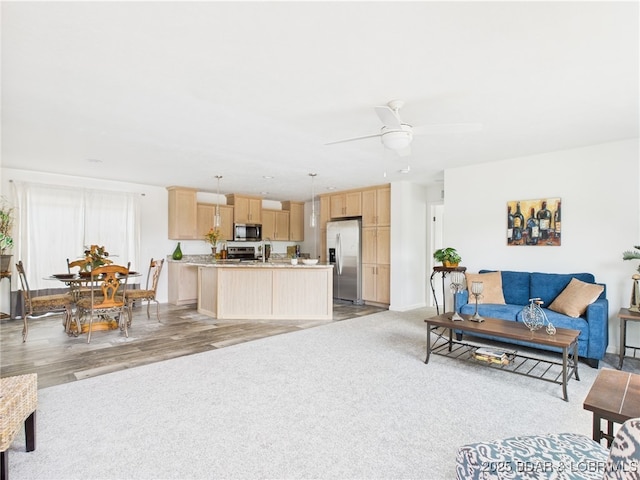 9A Pinkie Ln, Laurie, MO 65037 - living area with baseboards, light carpet, a ceiling fan, and light wood finished floors