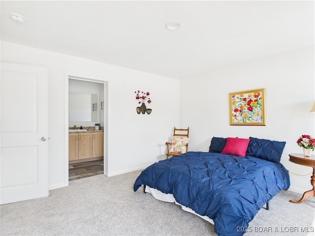 9A Pinkie Ln, Laurie, MO 65037 - bedroom featuring connected bathroom, baseboards, light colored carpet, and a sink