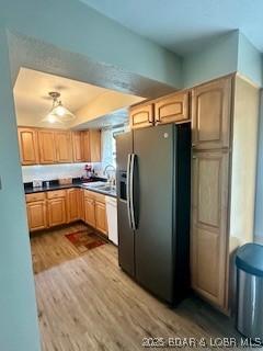 145 Costa Del Sol Dr Unit 2A, Lake Ozark, MO 65049 - kitchen featuring black fridge, wood finished floors, light brown cabinetry, and a sink
