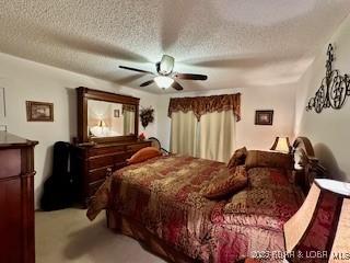 145 Costa Del Sol Dr Unit 2A, Lake Ozark, MO 65049 - carpeted bedroom featuring a textured ceiling and ceiling fan