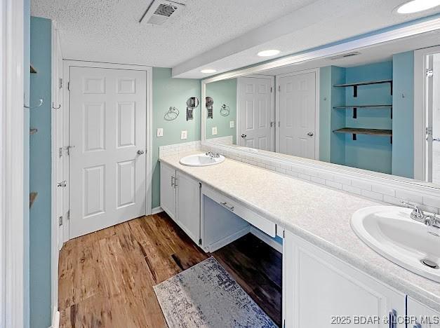 1117 Passover Rd Unit K-8, Osage Beach, MO 65065 - full bath with double vanity, wood finished floors, and a textured ceiling