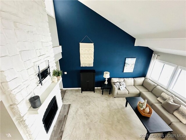 1117 Passover Rd Unit K-8, Osage Beach, MO 65065 - living area with a fireplace with raised hearth, vaulted ceiling, and carpet