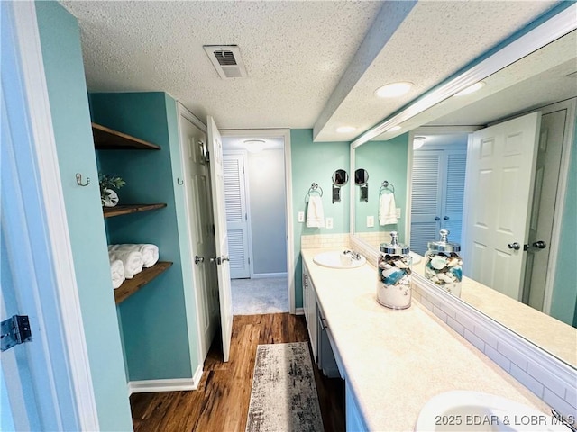 1117 Passover Rd Unit K-8, Osage Beach, MO 65065 - full bath with double vanity, a closet, wood finished floors, a textured ceiling, and recessed lighting