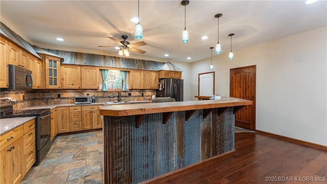 kitchen featuring decorative backsplash, a toaster, butcher block countertops, ceiling fan, and black appliances