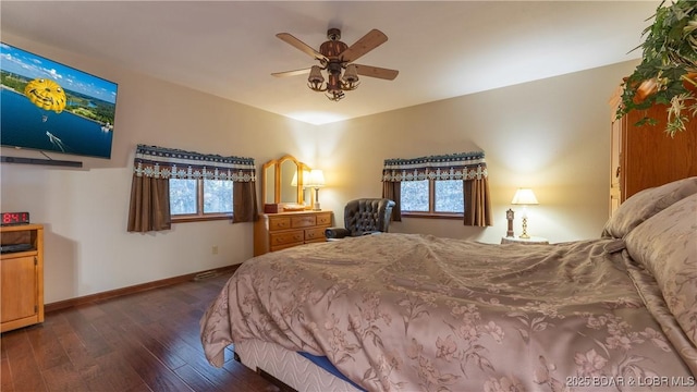 bedroom featuring baseboards, multiple windows, ceiling fan, and dark wood-type flooring