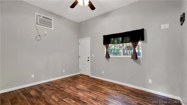 spare room with baseboards, a wall mounted air conditioner, dark wood finished floors, and ceiling fan