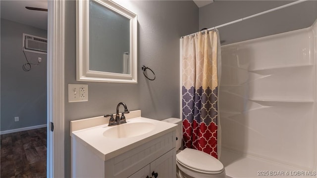 full bath featuring a wall mounted air conditioner, vanity, toilet, wood finished floors, and curtained shower