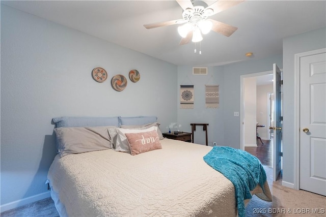 carpeted bedroom with a ceiling fan, baseboards, and visible vents