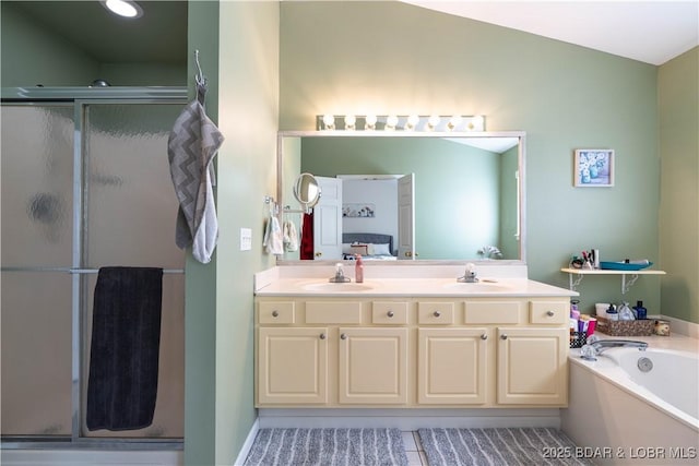 full bathroom with a sink, double vanity, a shower stall, and a bath
