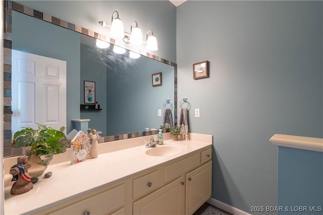 bathroom featuring vanity, baseboards, and a chandelier