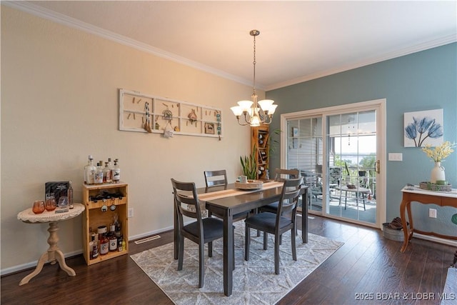 dining room featuring an inviting chandelier, ornamental molding, wood finished floors, and visible vents
