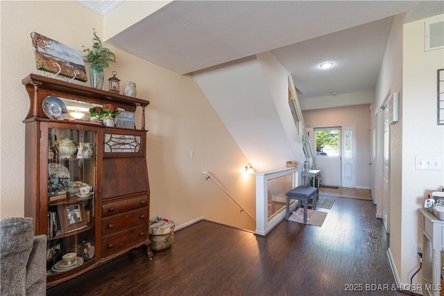 interior space with baseboards, wood finished floors, and an upstairs landing