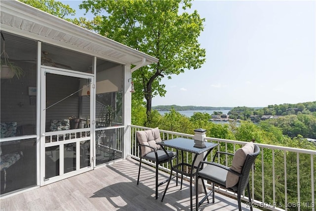 wooden deck with a water view and a sunroom