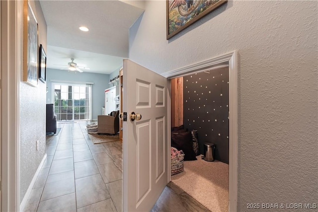 hallway with tile patterned flooring, recessed lighting, and a textured wall