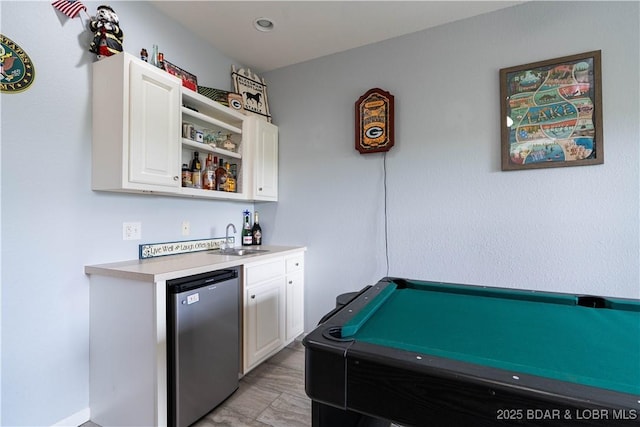 bar featuring a sink, indoor wet bar, and fridge