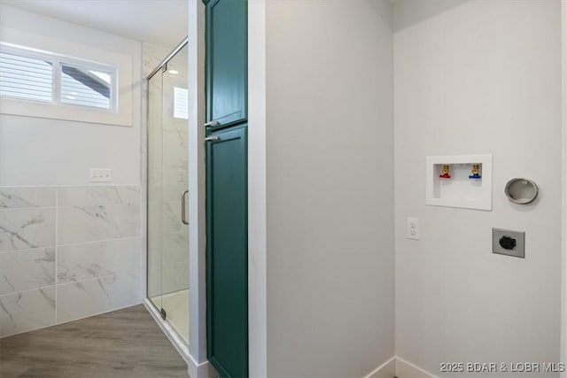 laundry room with hookup for an electric dryer, washer hookup, and wood finished floors