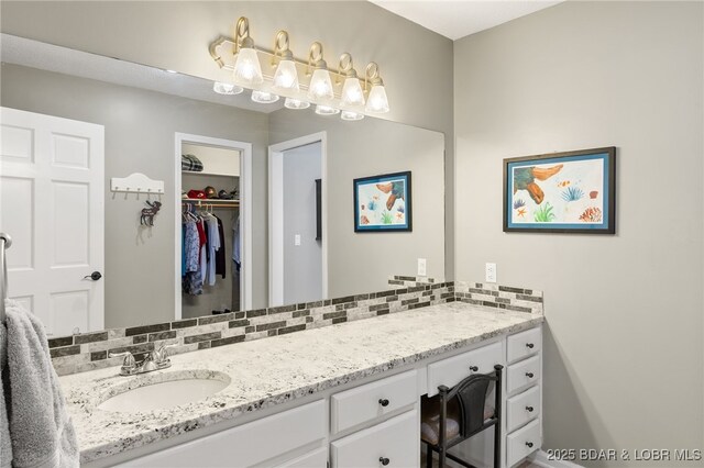 20168 Lost Valley Rd, Warsaw, MO 65355 - bathroom with vanity, a spacious closet, and decorative backsplash