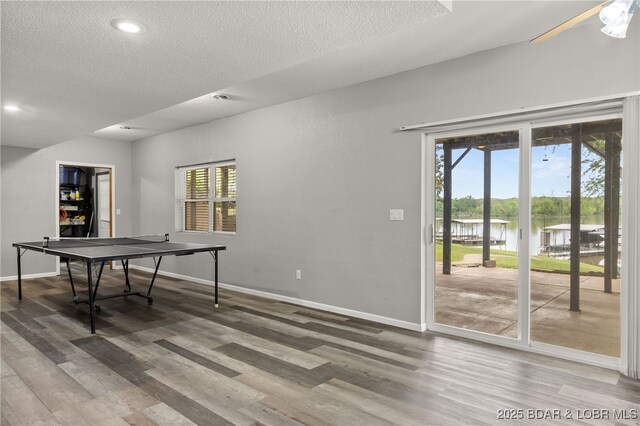 20168 Lost Valley Rd, Warsaw, MO 65355 - playroom with a water view, baseboards, a textured ceiling, wood finished floors, and recessed lighting