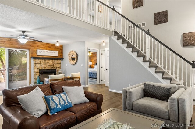 20168 Lost Valley Rd, Warsaw, MO 65355 - living room featuring wood finished floors, stairway, a ceiling fan, a fireplace, and baseboards