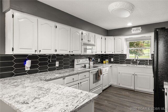 20168 Lost Valley Rd, Warsaw, MO 65355 - kitchen with white appliances, a sink, a peninsula, white cabinets, and tasteful backsplash