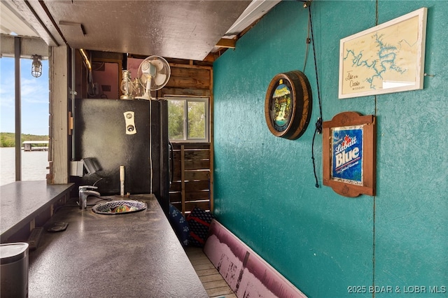 20168 Lost Valley Rd, Warsaw, MO 65355 - kitchen featuring freestanding refrigerator, a textured wall, and dark countertops