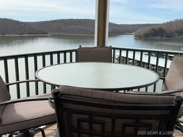 balcony with a water view and outdoor dining space