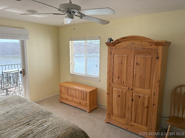 bedroom featuring access to outside, light carpet, and a ceiling fan