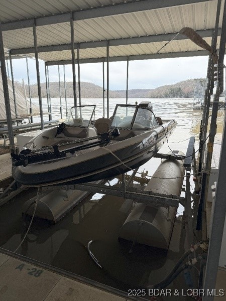 dock area with boat lift and a water view