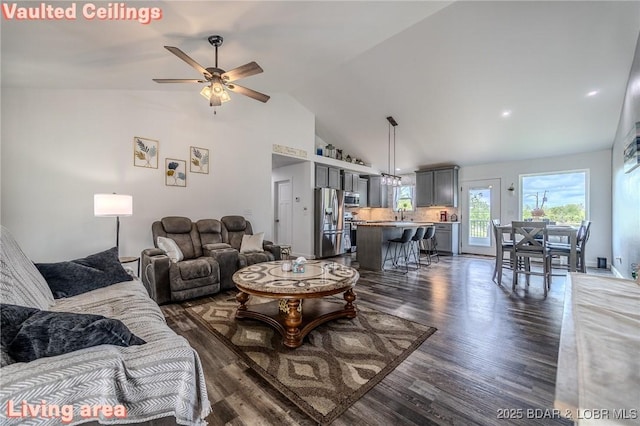 living area featuring dark wood-style flooring, a ceiling fan, and high vaulted ceiling