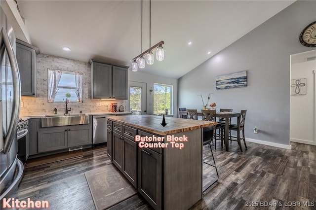 kitchen featuring butcher block countertops, a sink, appliances with stainless steel finishes, and a wealth of natural light