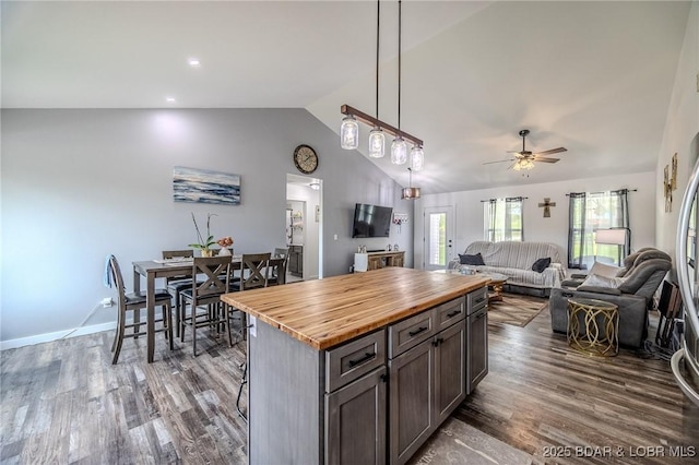 kitchen with ceiling fan, dark wood-style flooring, vaulted ceiling, butcher block counters, and open floor plan