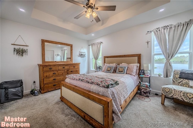 carpeted bedroom featuring a raised ceiling, baseboards, a ceiling fan, and recessed lighting