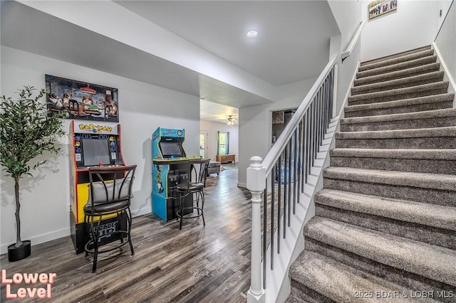 staircase featuring recessed lighting, baseboards, and wood finished floors