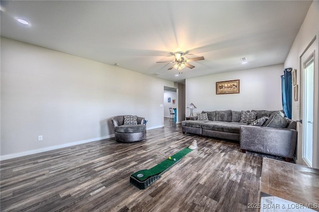 living area featuring a ceiling fan, baseboards, and wood finished floors