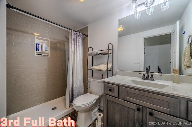 bathroom with vanity, toilet, and tiled shower