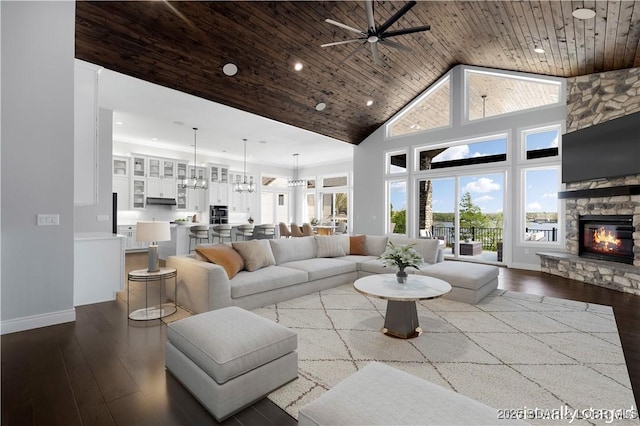 living room with baseboards, hardwood / wood-style floors, ceiling fan, and high vaulted ceiling