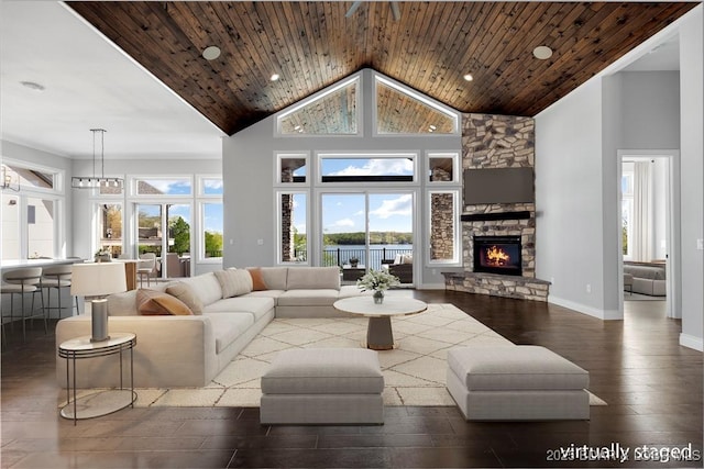 living area featuring wood finished floors, high vaulted ceiling, recessed lighting, baseboards, and a stone fireplace