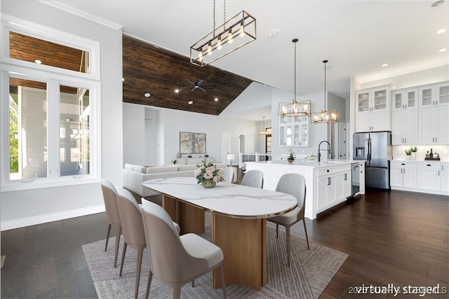 dining room with ceiling fan with notable chandelier, dark wood-type flooring, recessed lighting, vaulted ceiling, and baseboards
