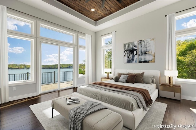 bedroom with dark wood-type flooring, wooden ceiling, a raised ceiling, baseboards, and access to exterior