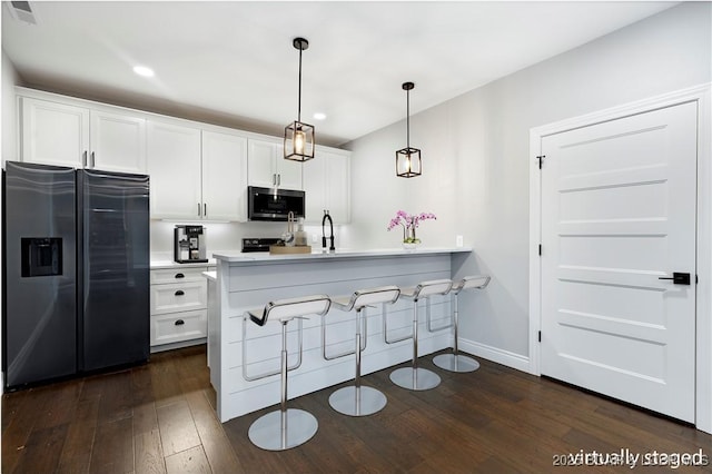 kitchen featuring dark wood-style flooring, a peninsula, white cabinetry, and appliances with stainless steel finishes