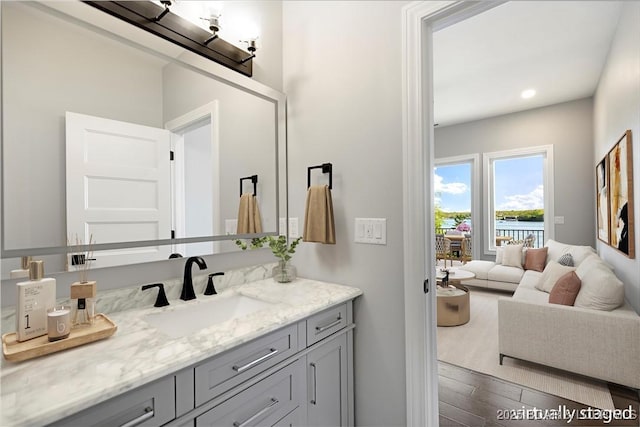 bathroom with wood finished floors, vanity, and recessed lighting
