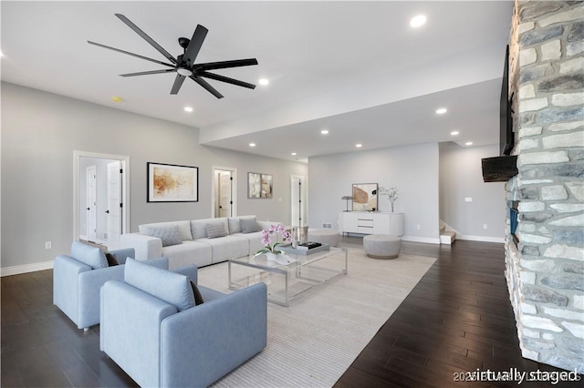 living room featuring baseboards, a fireplace, and dark wood-style floors
