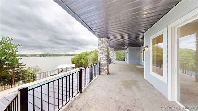 view of patio / terrace featuring a water view, ceiling fan, and fence